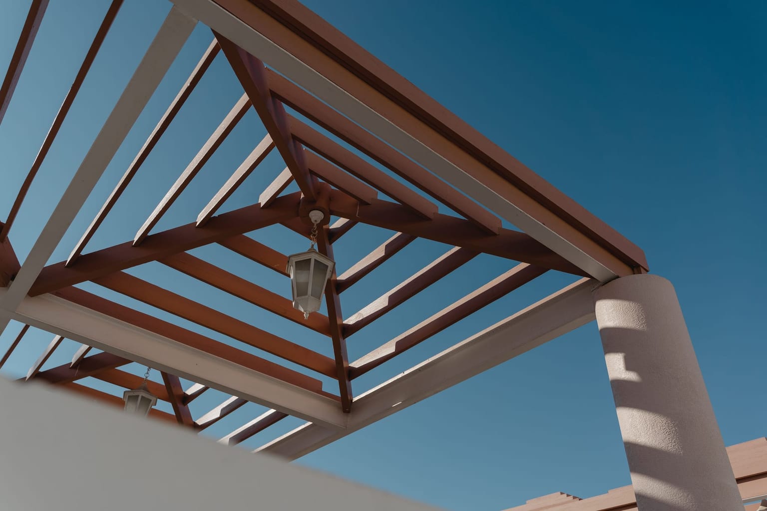 Poutres et chevrons d'une pergola vus en contre-plongée