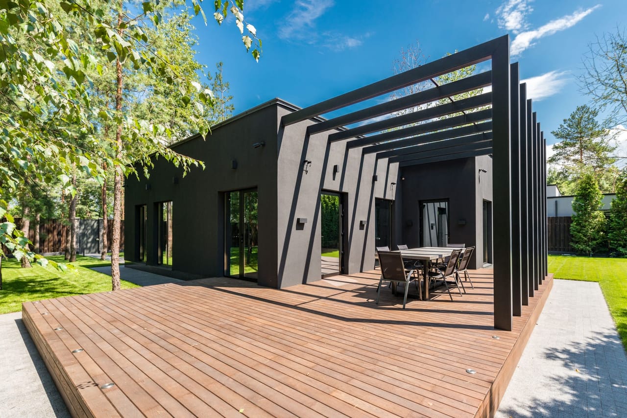 Terrasse bois avec table de repas, entourée de végétation