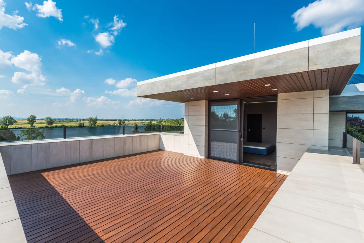 Grande terrasse en bois exotique surplombant un paysage de campagne