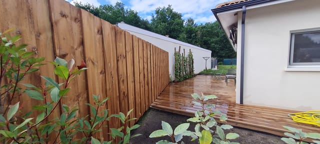 Clôture bois pleine hauteur le long d'une terrasse en pin