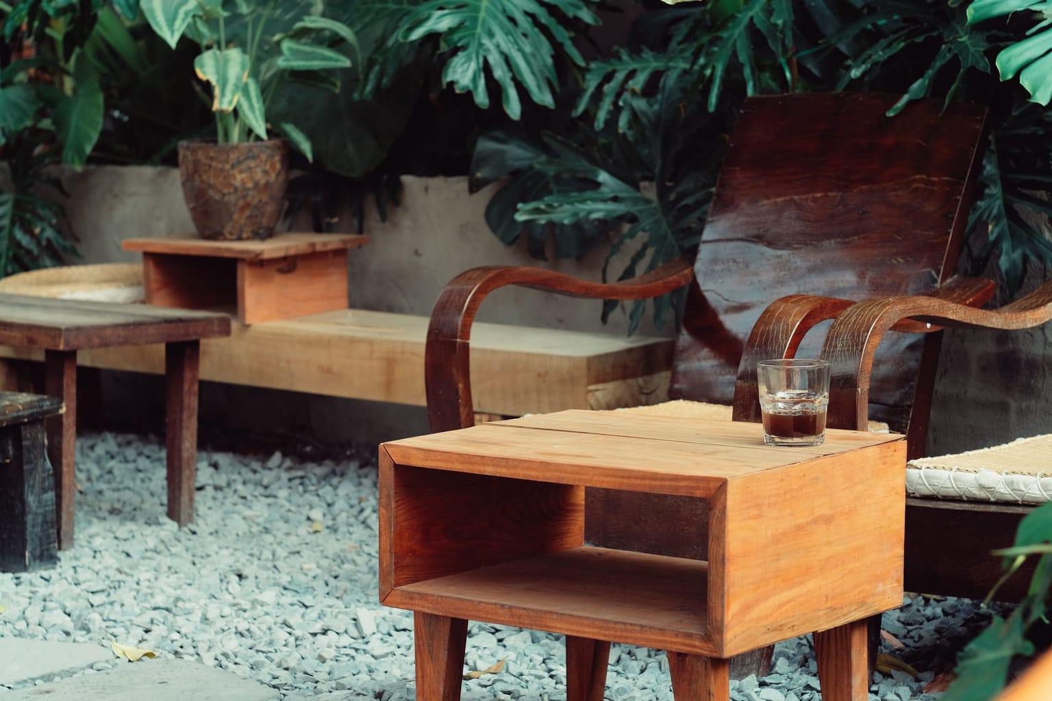 Coin salon en bois installé dans un petit jardin planté