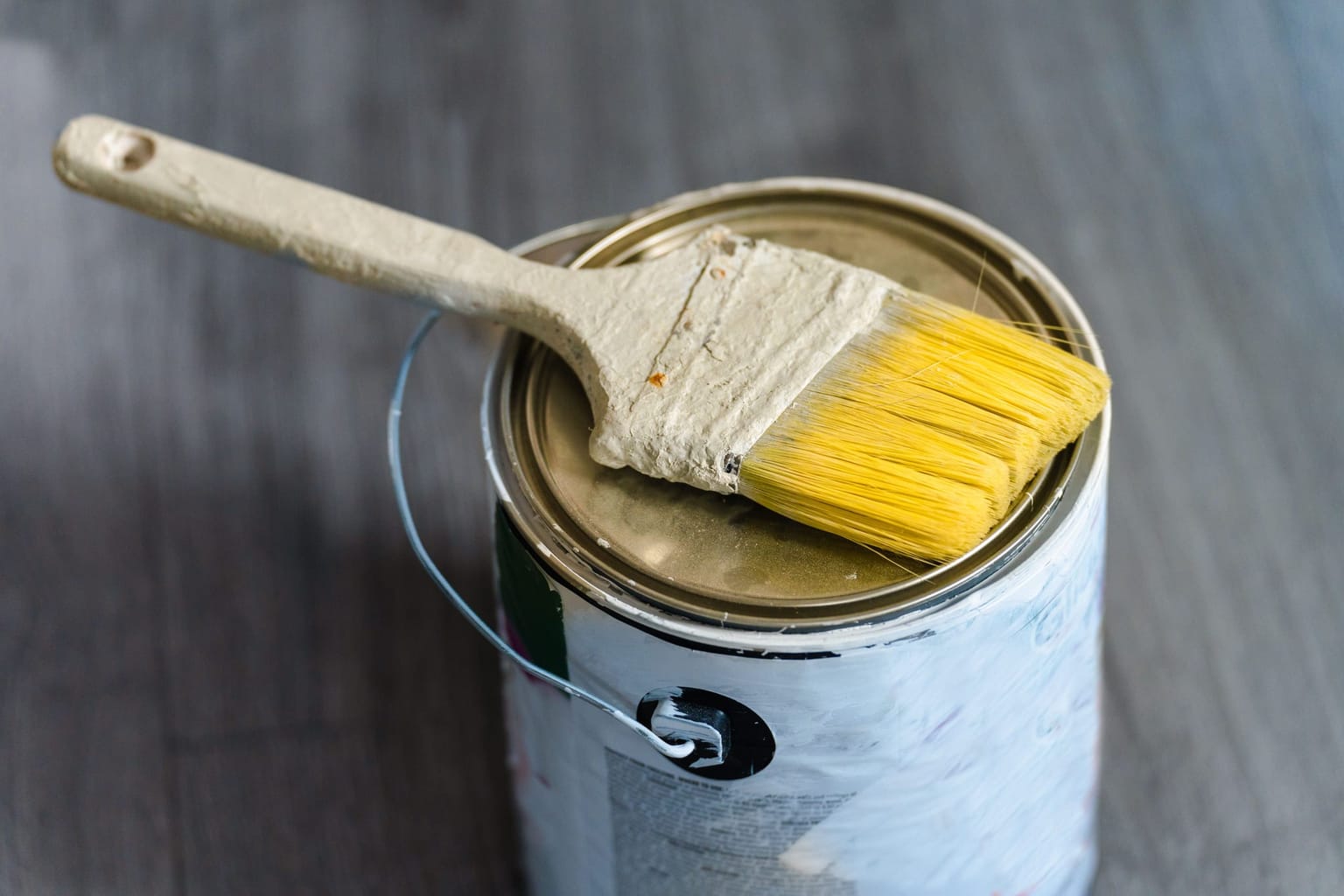 Pinceau posé sur un pot de produit de protection du bois