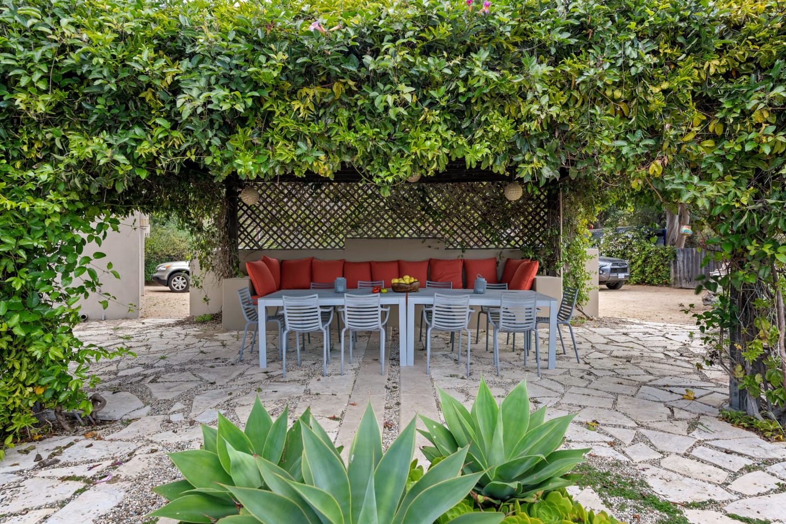 Coin repas abrité sous une pergola envahie de verdure