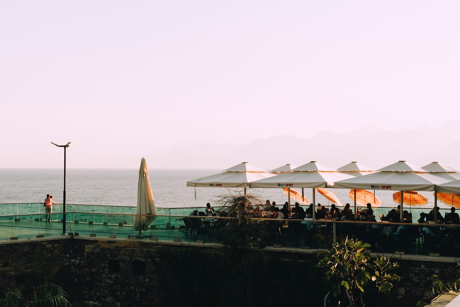 Terrasse ombragée par une rangée de parasols en fin de journée