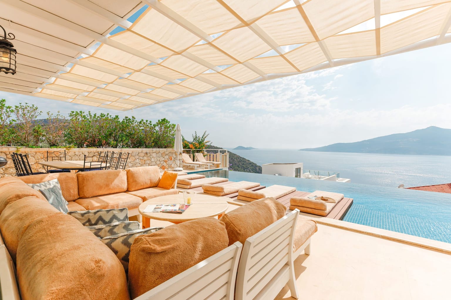 Terrasse couverte par une pergola à lames, face à la mer