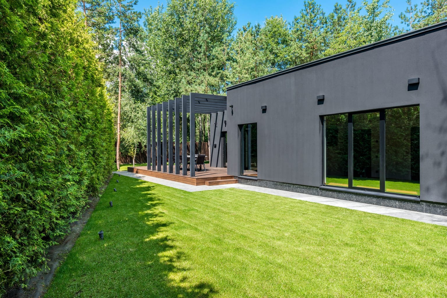 Pergola adossée à une maison contemporaine avec pelouse