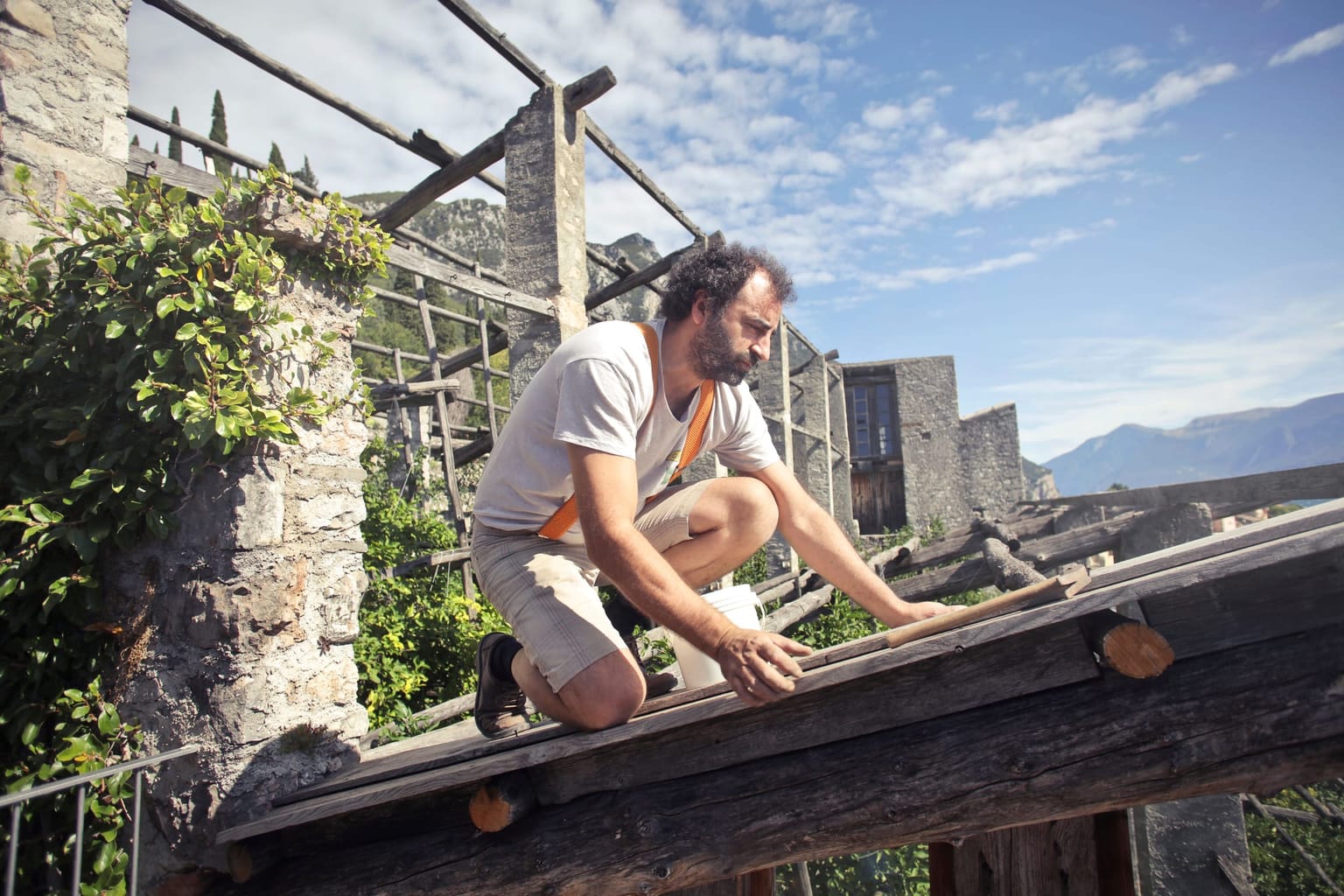 Artisan reprenant l'ossature bois d'une structure extérieure