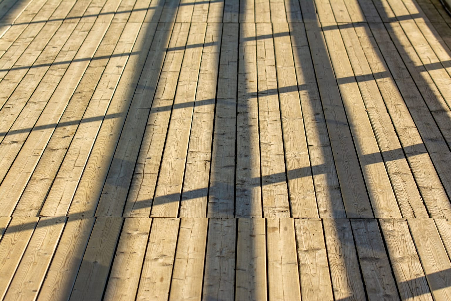 Lames de terrasse bois neuves éclairées en lumière rasante